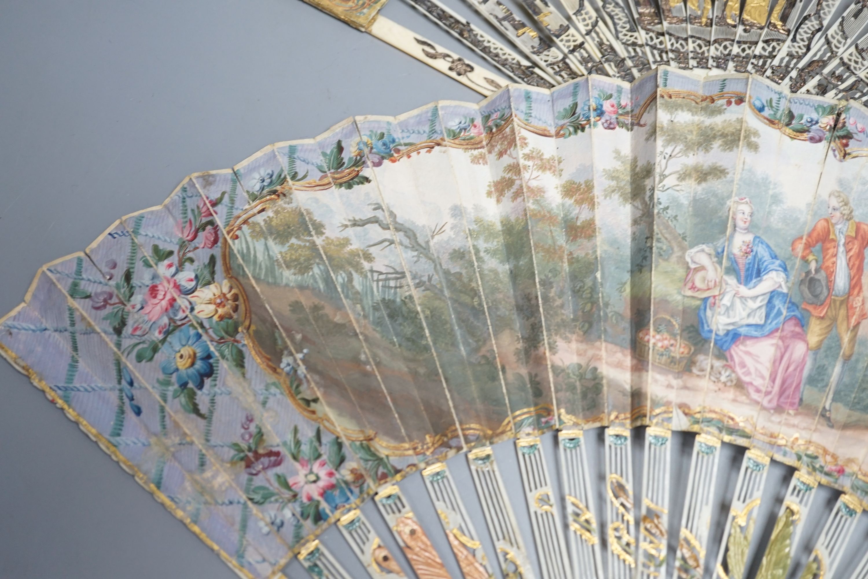 Two late 18th/early 19th century French gilded and silvered ivory and painted paper leaf fans